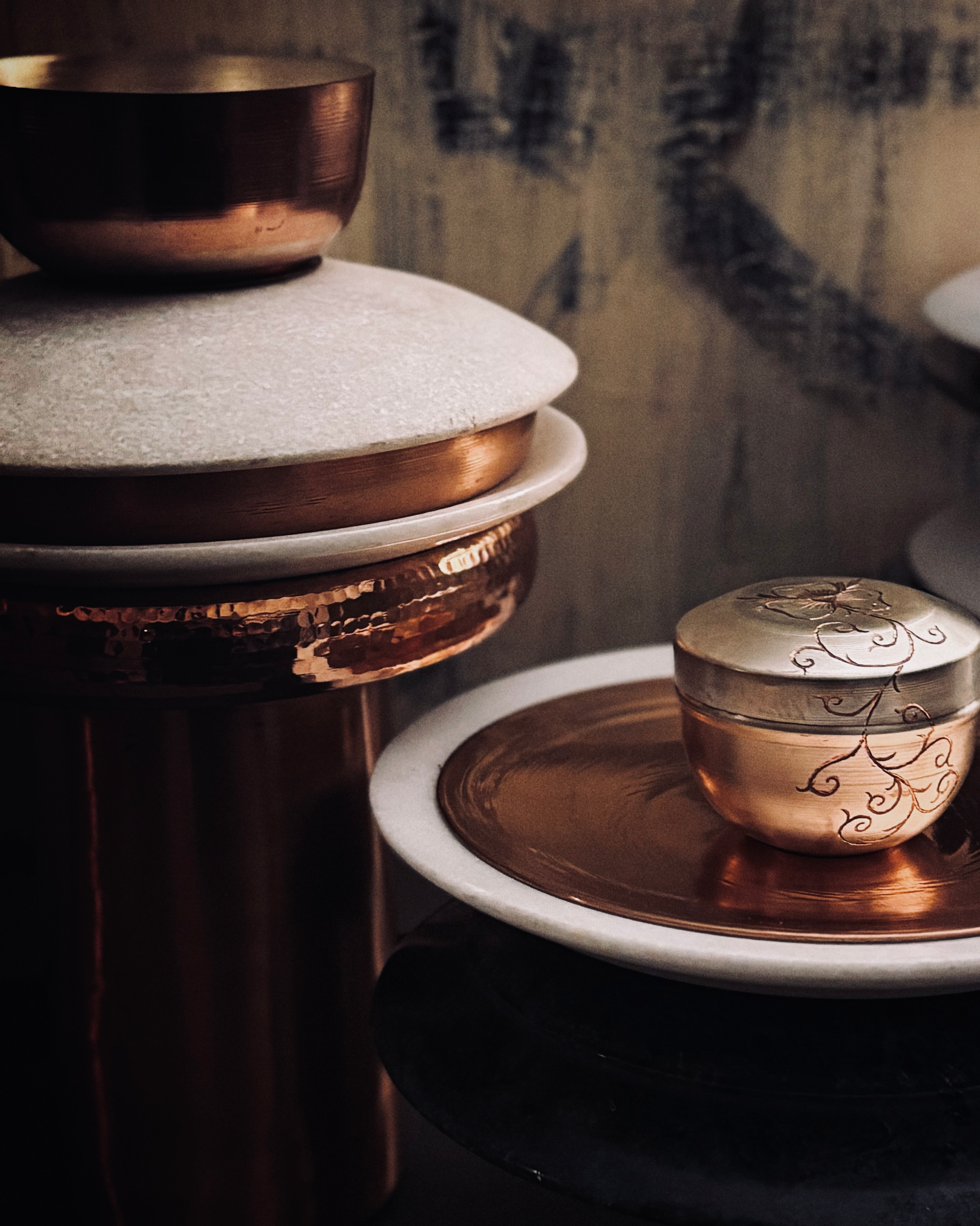 Decorative setting with a small bowl and a candle on a textured surface