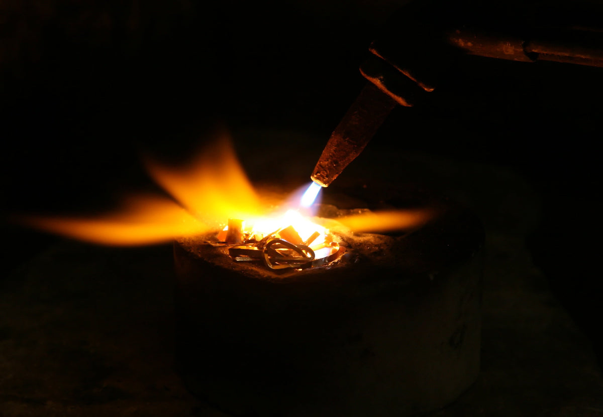 Flame from a torch interacting with metal in a dark setting